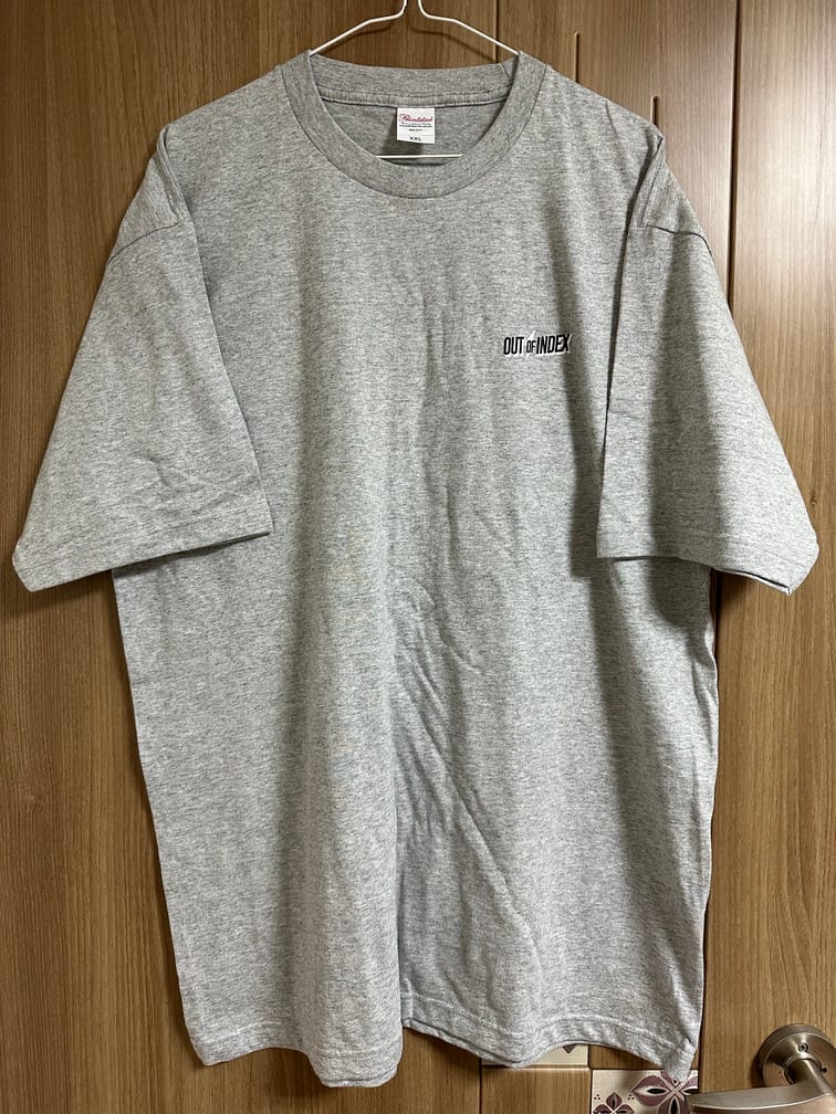 왼쪽 가슴부분에 OUT OF INDEX라는 로고가 박혀 있는 거친 회색 티셔츠.